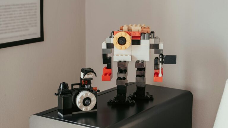 a lego robot sitting on top of a table next to a camera