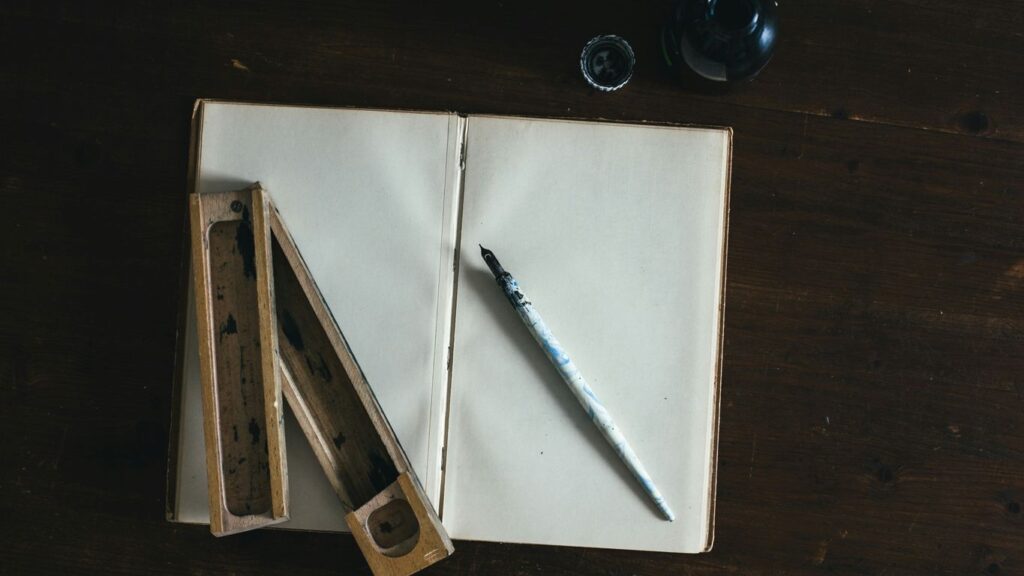 white fountain pen on white open book