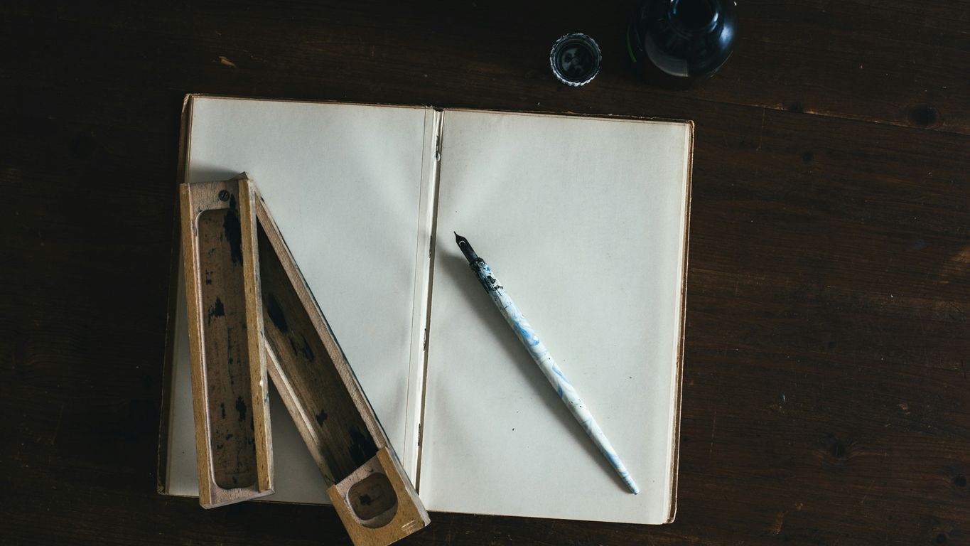 white fountain pen on white open book